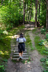 woman walking up by old stairs in forest