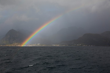 Colorful Rainbow in the Arctic ocean, Reine, Lofoten islands, Norway.