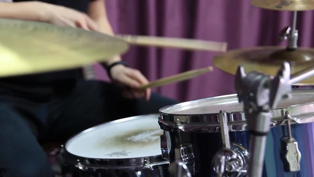 The guy plays the drums. Shooting through the drums