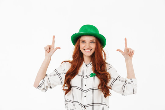 Happy young redheaded girl wearing green hat