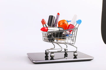 Shopping cart with cosmetics is on the smartphone. Online sales concept.