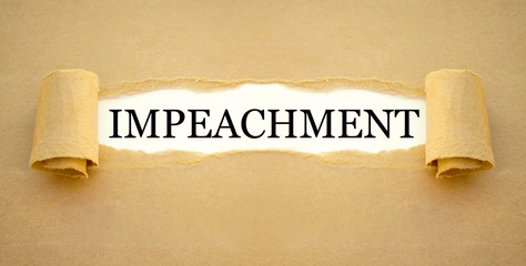 Golden sign with gavel on a desk with impeachment and law books