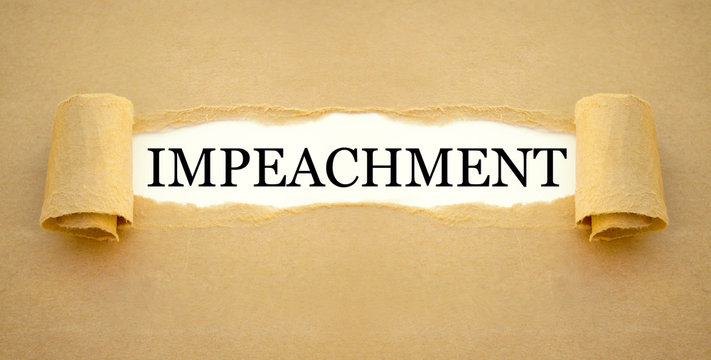 Golden sign with gavel on a desk with impeachment and law books