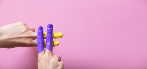female hands in paint crossed in a hashtag sign on a colored background, creative advertising,...