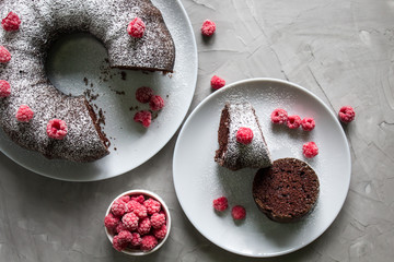 cut the homemade chocolate cake with raspberries on a grey background. Lean baking. Top view
