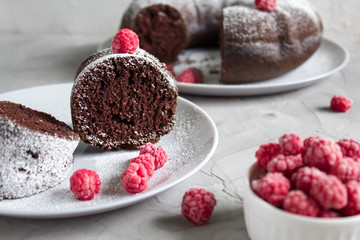 homemade chocolate cake with raspberry on grey background. Lean baking. Cut cake close-up.