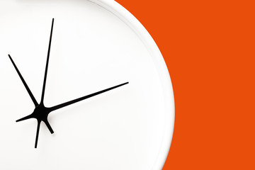 White round clock with black arrows isolated on orange background. Empty copy space time texture.