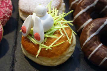 Osterhase aus Fondant krabbelt in Berliner Blume guckt raus