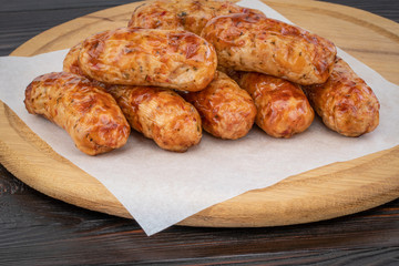 Tasty grilled sausage on the wooden background