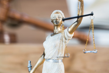 Themis , symbol of law and justice on wooden background