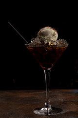 cocktail in a glass with ice cream as a decoration on a dark background