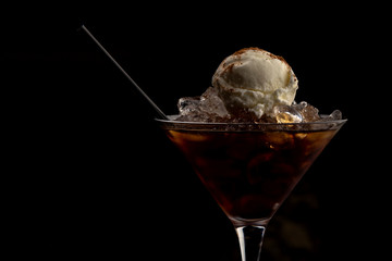 cocktail in a glass with ice cream as a decoration on a dark background