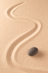 Zen stone Japanese meditation sand garden for focus and concentration on balance and spirituality. Yoga or spa wellness sandy background with round rock and open copy space.