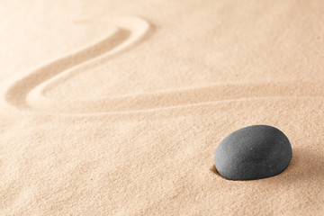 black zen meditation stone in Japanese sand garden. Concept for harmony and balance in yoga and mindfulness.