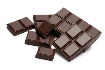 Dark organic chocolate pieces isolated on white background