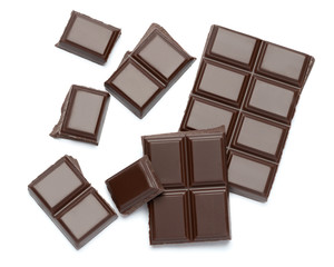 Dark organic chocolate pieces isolated on white background