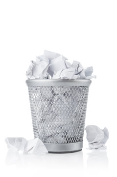 Waste paper in rubbish bin on white background