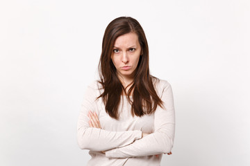 Obraz premium Portrait of serious strict young woman in light clothes looking camera holding hands crossed isolated on white wall background in studio. People sincere emotions lifestyle concept. Mock up copy space.
