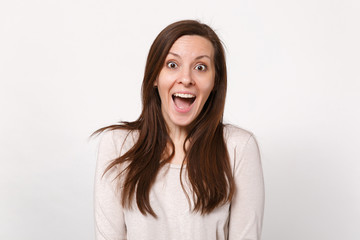 Obraz premium Portrait of surprised excited beautiful young woman in light clothes keeping mouth wide open isolated on white wall background in studio. People sincere emotions lifestyle concept. Mock up copy space.