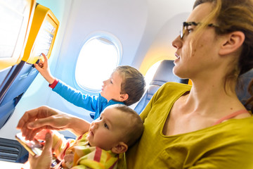 Obraz premium Family of mother, child and baby traveling sitting in the seats of an airplane.