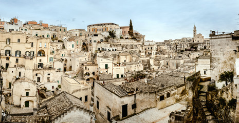 Fototapeta na wymiar Panoramic view of Matera (Sassi di Matera) with its steep ancient stone streets, European Capital of Culture 2019, with clouds, at southern Italy, waiting to welcome tourists.