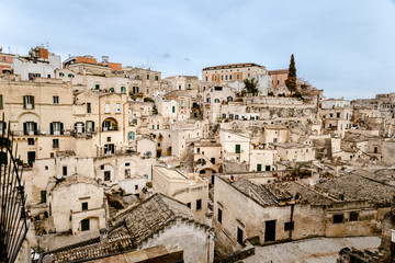 Fototapeta na wymiar Panoramic view of the city of Matera in Italy, ancient curious village for tourists to be built inside the rocks in caves and stone houses, seen from the top.