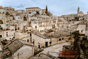 Naklejka premium Panoramic view of the city of Matera in Italy, ancient curious village for tourists to be built inside the rocks in caves and stone houses, seen from the top.