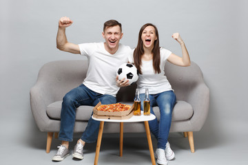 Cheerful couple woman man football fans in white t-shirt cheer up support favorite team with soccer...