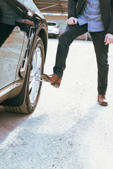 Obraz premium Man tightens lug nuts of a car. Safe driving concept.