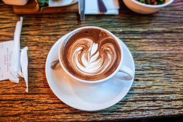 Hot latte art coffee on wood table