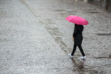  portrait of woman with pink umbrella on cobbles place in the city on top view