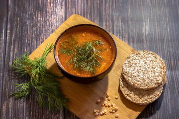 Vegan pea soup with dill and bread on a dark background