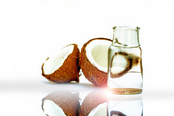 Raw organic cut brown colored dried coconut isolated on white along with its water and reflection.