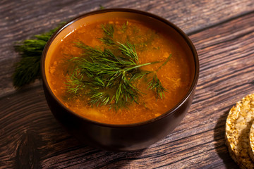 Vegan pea soup with dill and bread on a dark background