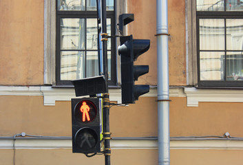 Red traffic light on city street in front of old building facade. Stop signal showing a standing...