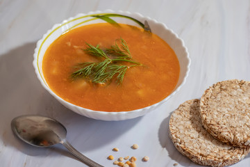 Veggie pea soup with carrots and dill on a white background