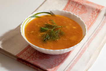 Vegetarian pea soup with dill and bread rolls on a linen napkin and a white background