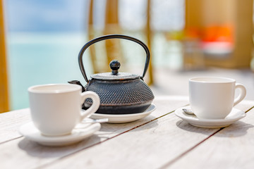 Traditional japanese herbal tea recipe prepared in cast iron teapot with organic dry herbs. Alternative medicine. Healthy asian green tea in tea pot on vintage wooden table background