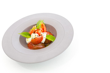 Tomato and mozzarella salad with salmon filet, gourmet food background 