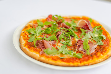 Pepperoni pizza with salami and cheese and rucola salad. TOP VIEW Tasty traditional pepperoni pizza on board on white table with decoration. Copy space for your logo. Ideal for commercial 