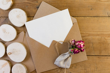 Naklejka na ściany i meble Craft brown envelope with dry flowers on wood background.