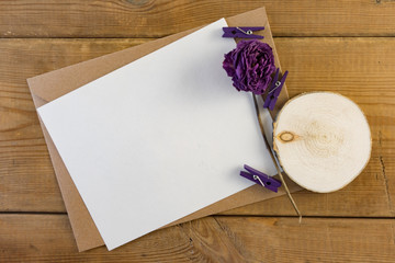 Craft brown envelope with dry flowers on wood background.