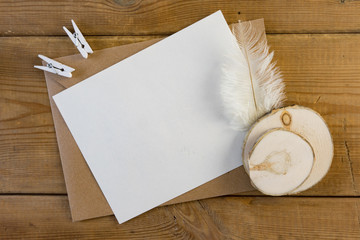 Craft brown envelope with feather on wood background.