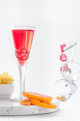 red non-alcoholic aperitif with chips and slices of orange on a white background 