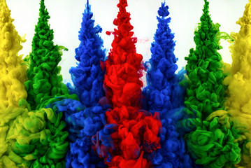 The swirl of ink in water isolated on white background. Multi-colored paint mixed in the water close-up