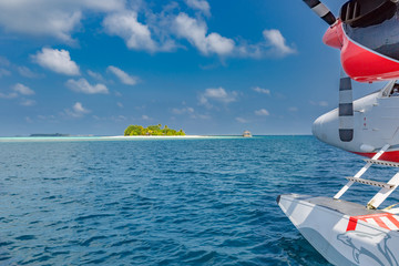 Seaplane landing in Maldives islands blue sea. Exotic tropical vacation and holiday background 