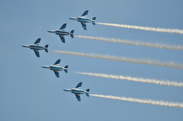 blue and white fighter jets flying in formation