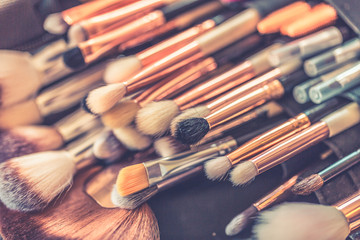 Makeup brushes set in case. Set of brushes for makeup scattered chaotically on wooden background