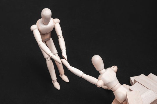 Helping hand. Support and problem solution. Teamwork and cooperation. Conceptual articulated mannequin composition.