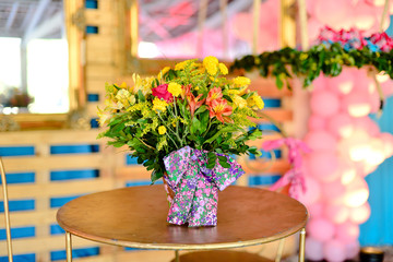 golden round table with vase of colorful flowers, vintage decoration, golden table with wildflowers, birthday party